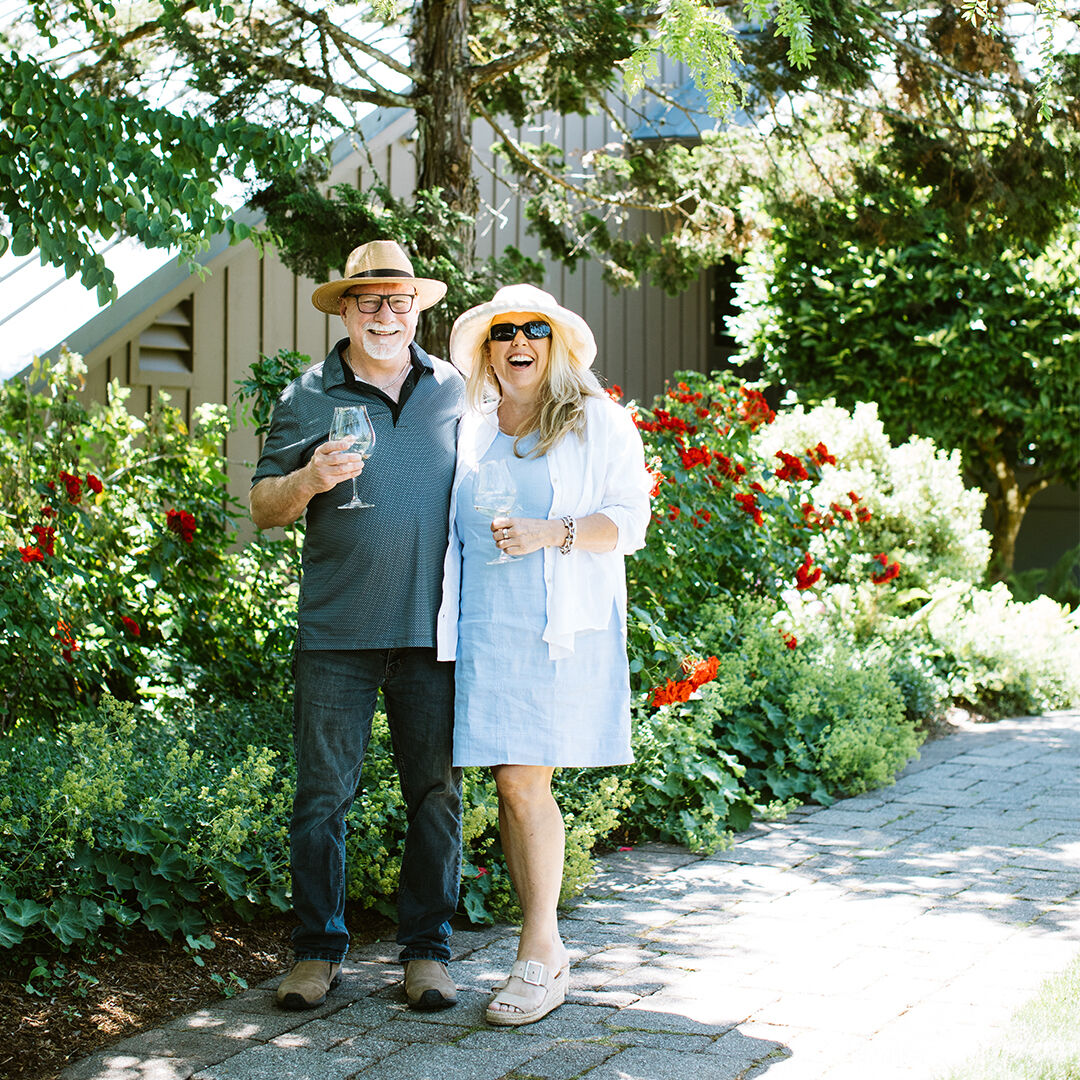 Couple standing in front of rose bushes outside of WillaKenzie Estate.