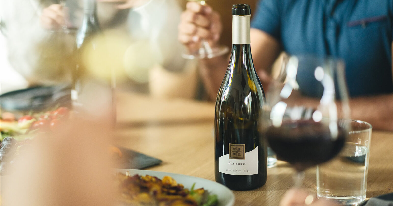 A bowl of pasta and a bottle of wine.