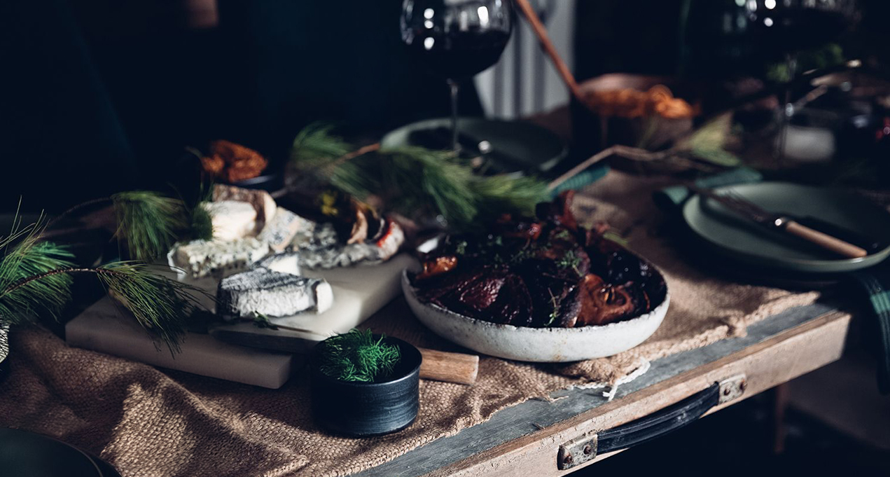 A glass of WillaKenzie wine next to a bowl of duck