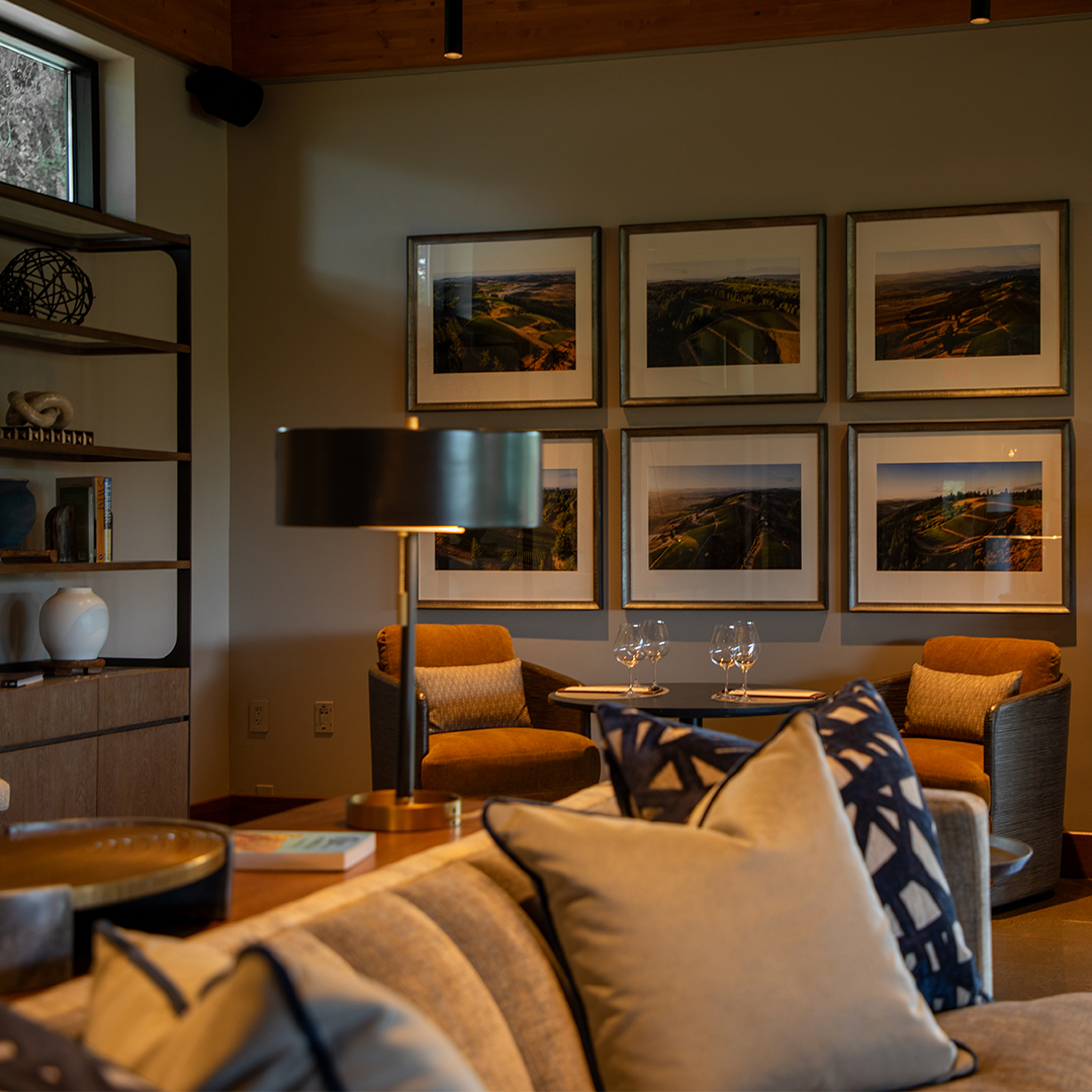 A view of the new WillaKenzie tasting room with 6 framed photos of WillaKenzie vineyard neighborhoods.